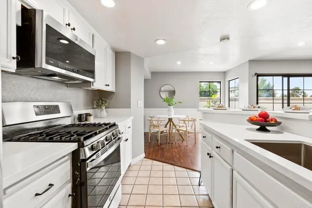 a kitchen with stainless steel appliances a sink stove and cabinets