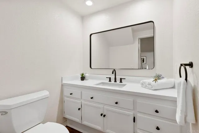a bathroom with a toilet sink and mirror