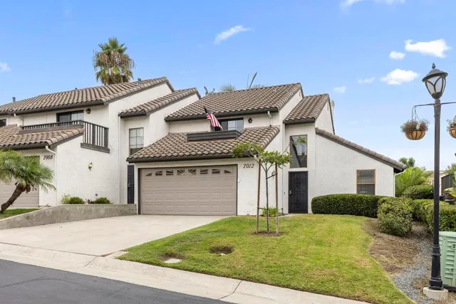 a view of a white house with a yard and plants