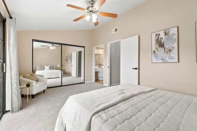 a bedroom with a large bed and a chandelier