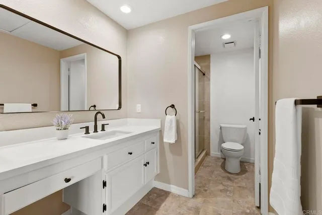 a bathroom with a toilet a sink and mirror