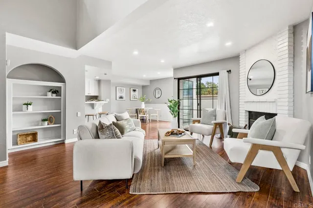 a living room with fireplace furniture and a large window