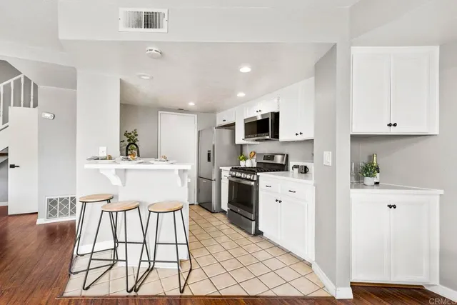 a kitchen with white cabinets and appliances
