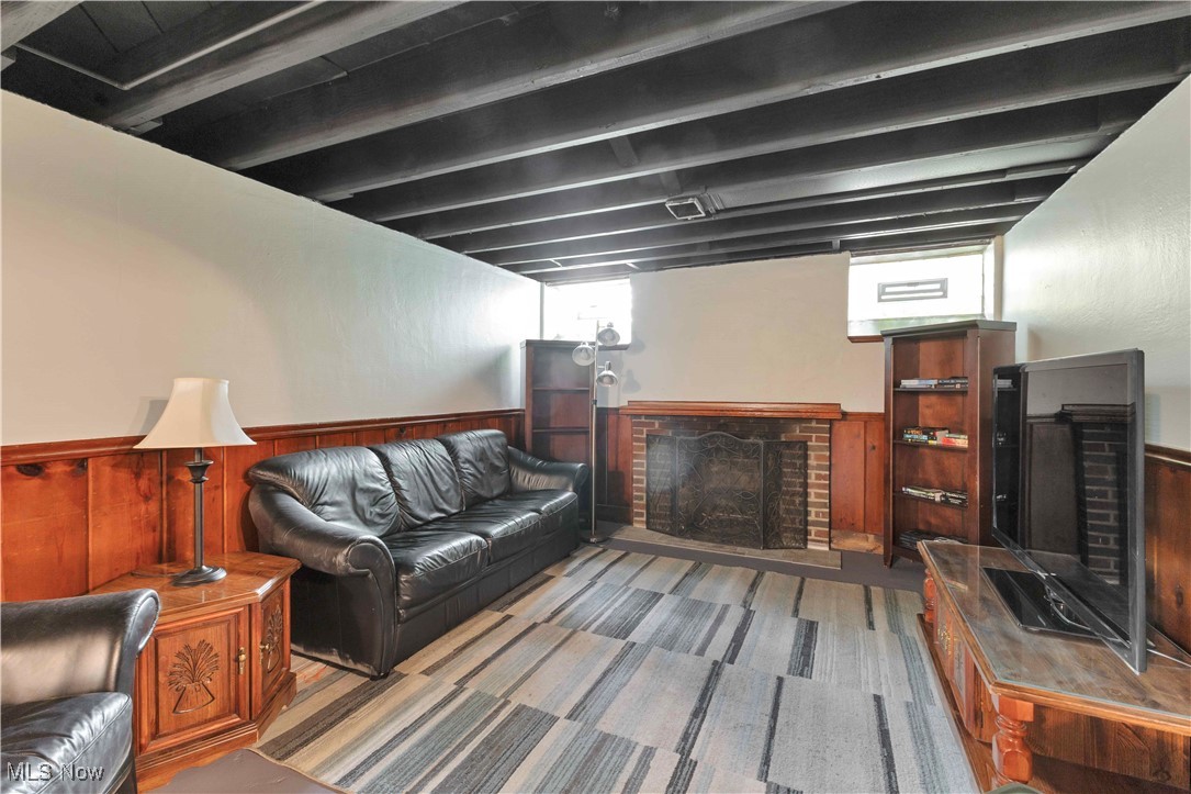 3385 Rosedale Road Cleveland, OH 44112 - Photo 28 of 40 Living area featuring a wainscoted wall, a fireplace, wooden walls, and beam ceiling
