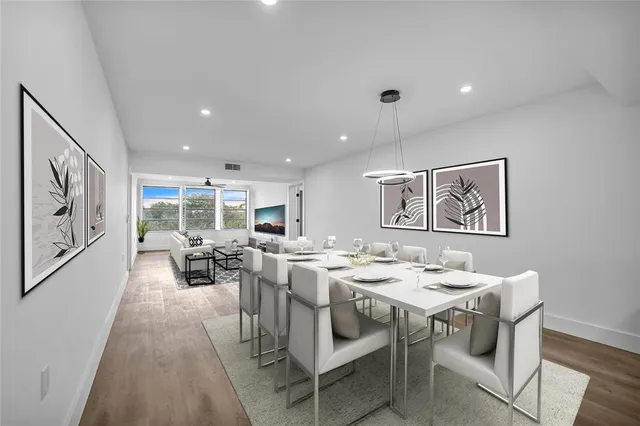 a view of a dining room with furniture a rug and wooden floor