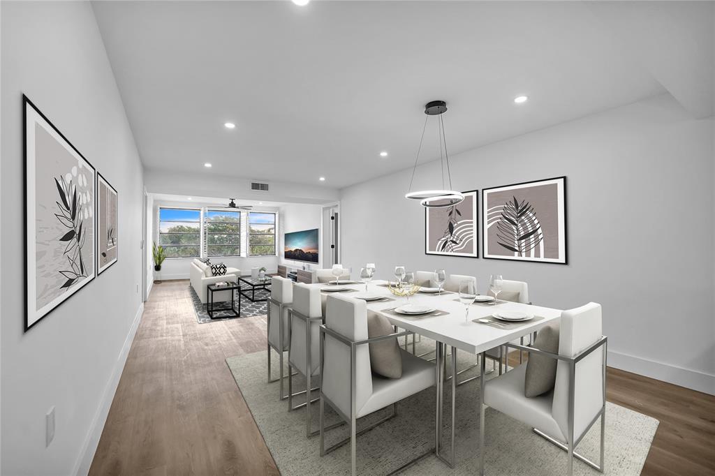 a view of a dining room with furniture a rug and wooden floor