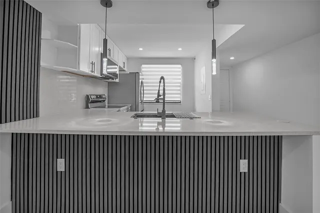 a kitchen with kitchen island granite countertop a sink window and a counter top space