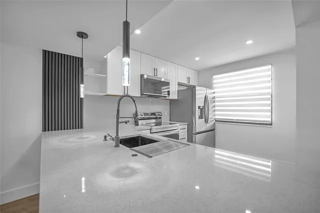 a kitchen with stainless steel appliances a sink stove and refrigerator