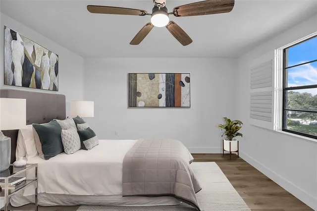 a bedroom with a bed and wooden floor