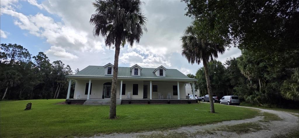 a front view of a house with a garden and trees