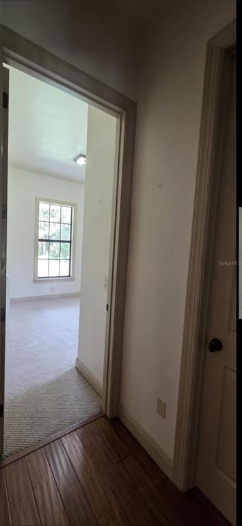 8991 Southwest Springhaven Avenue Indiantown, FL 34956 - Photo 18 of 30 an empty room with wooden floor and windows