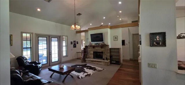 a living room with furniture a flat screen tv and a floor to ceiling window