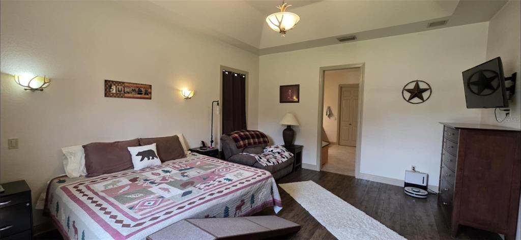 8991 Southwest Springhaven Avenue Indiantown, FL 34956 - Photo 10 of 30 a bedroom with a bed and wooden floor