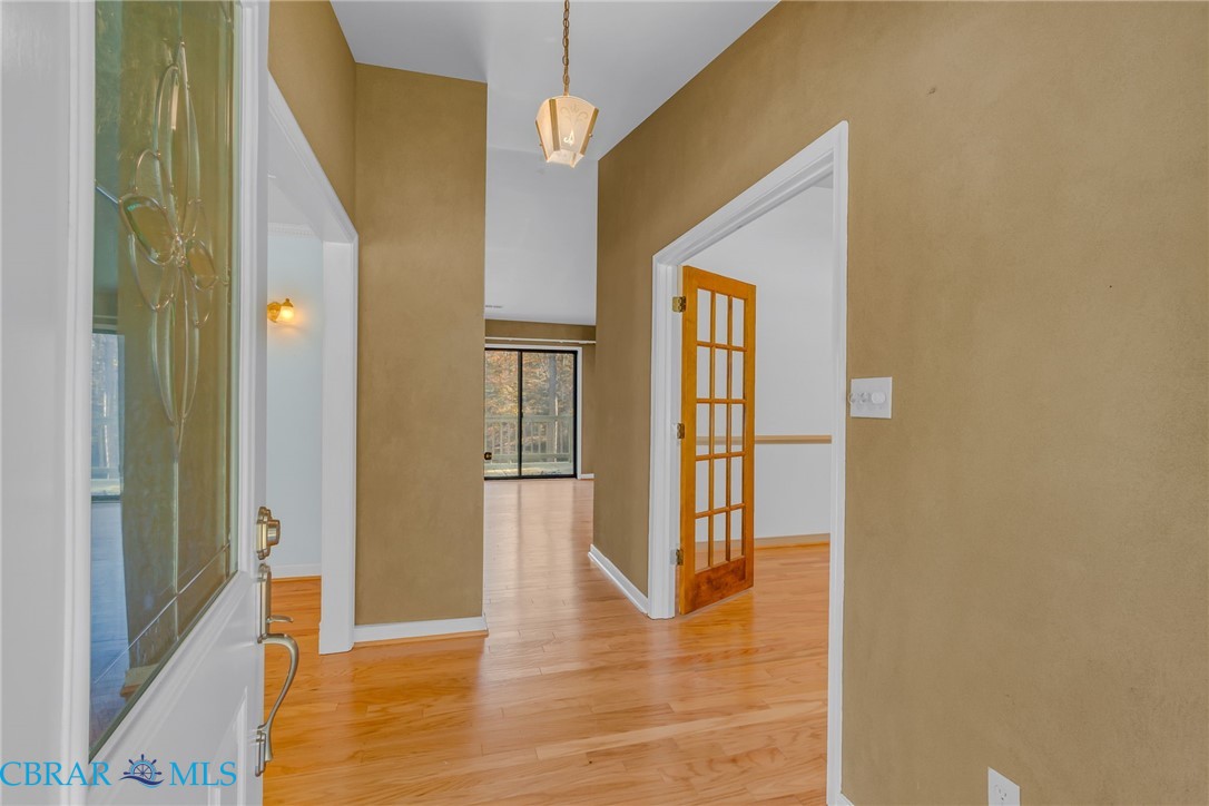 Hallway featuring light wood-type flooring and baseboards