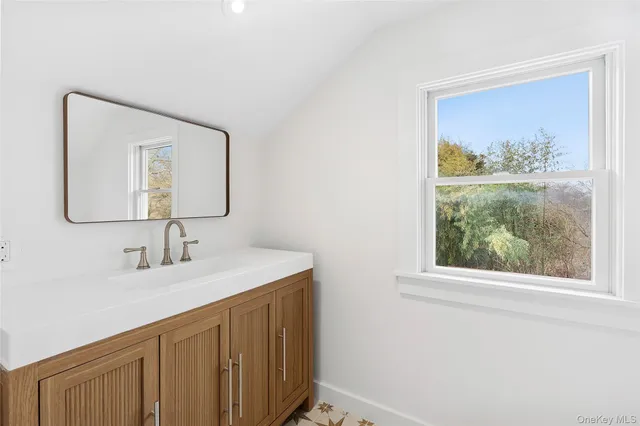 a bathroom with a sink vanity and a mirror