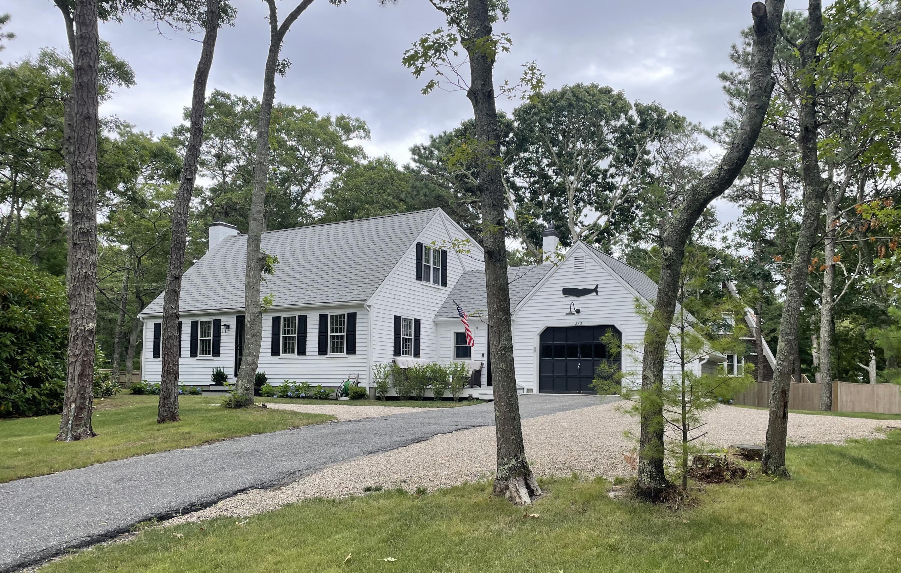 863 Bumps River Road Centerville, MA 02632 - Photo 2 of 22 a front view of a house with a yard and garage