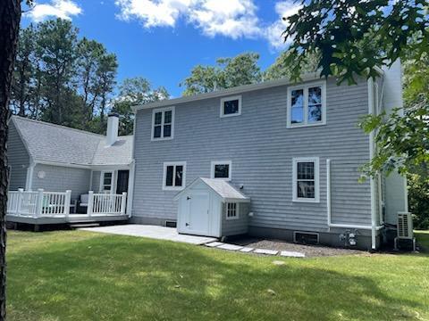 863 Bumps River Road Centerville, MA 02632 - Photo 3 of 22 a front view of a house with a yard and garage