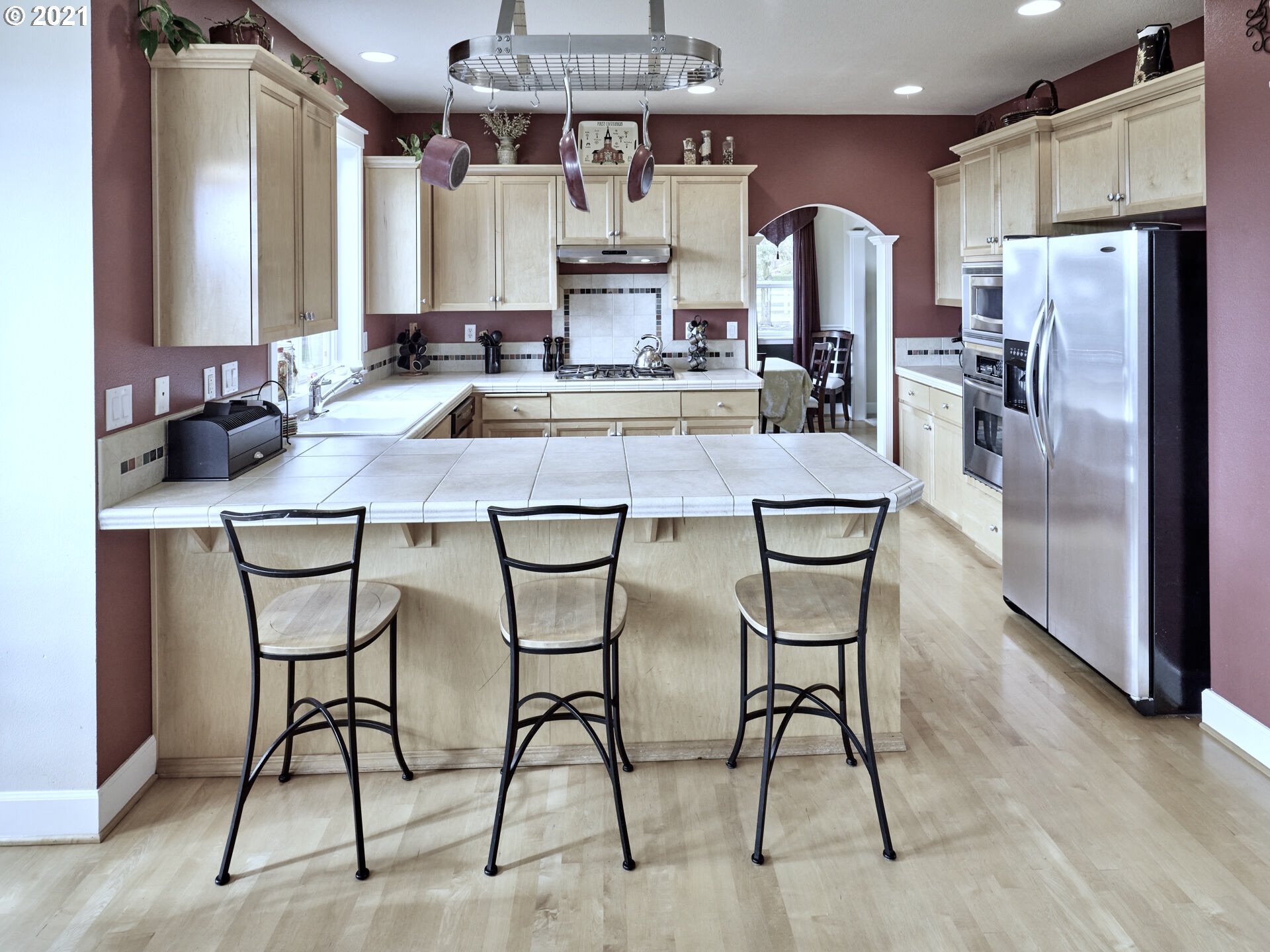 3934 Mission Road Northeast St. Paul, OR 97137 - Photo 11 of 32 a kitchen with stainless steel appliances kitchen island granite countertop a dining table chairs and a refrigerator