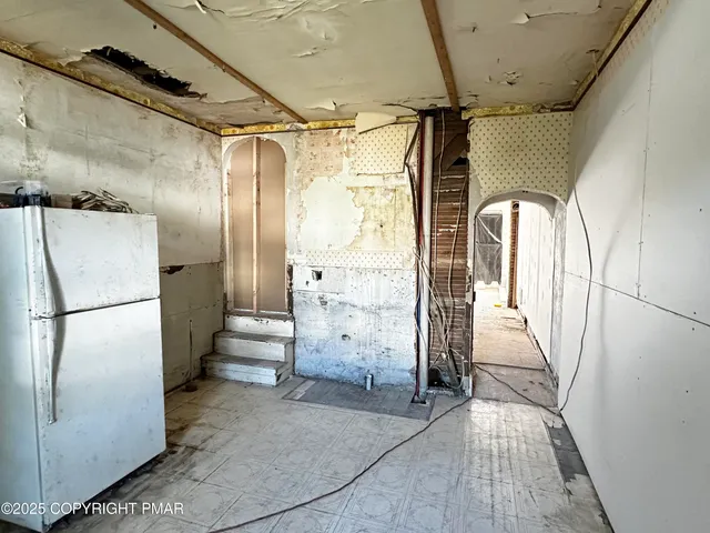 a view of a refrigerator in kitchen and entryway