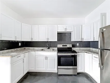 a kitchen with white cabinets and white appliances
