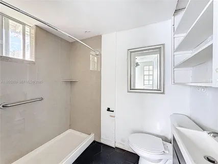 a white toilet sitting next to a bathroom sink