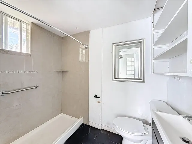 a white toilet sitting next to a bathroom sink