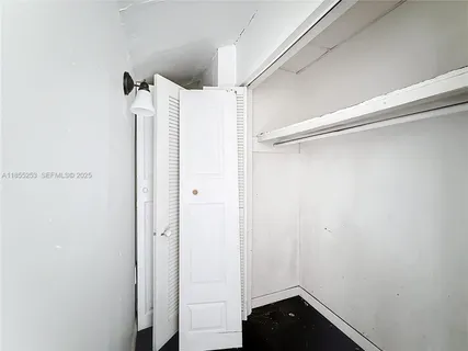 a view of walk in closet with empty racks
