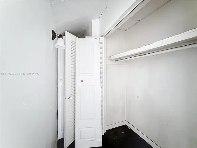 a view of walk in closet with empty racks