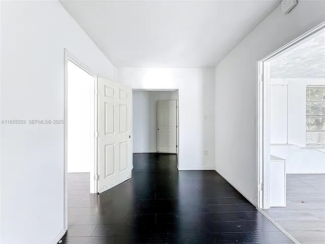 a view of an empty room with wooden floor