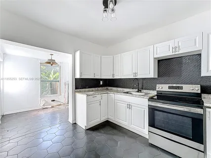 a kitchen with a stove a sink and a microwave