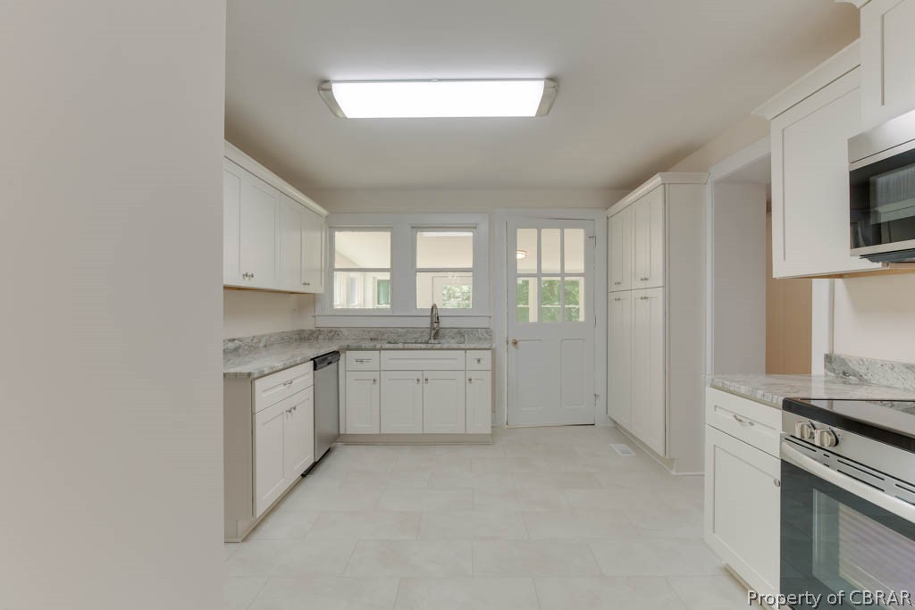 400 Showalter Road Yorktown, VA 23692 - Photo 14 of 49 Kitchen featuring light tile patterned flooring, appliances with stainless steel finishes, sink, and white cabinets