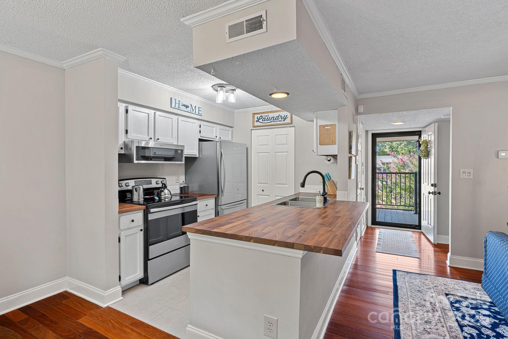 11017 Running Ridge Road Charlotte, NC 28226 - Photo 1 of 27 a large kitchen with stainless steel appliances granite countertop a stove oven a sink dishwasher and white cabinets with wooden floor