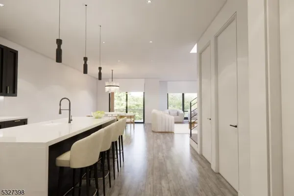 a open kitchen with stainless steel appliances granite countertop a dishwasher a stove a sink dishwasher and a dining table with wooden floor