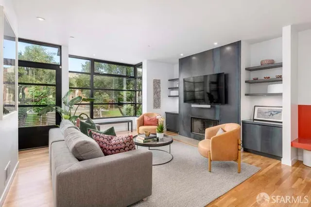 a living room with furniture floor to ceiling window and a flat screen tv
