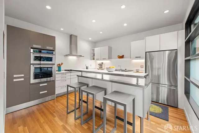 a kitchen with stainless steel appliances a refrigerator and a stove top oven