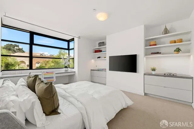 a bedroom with a bed and a large window