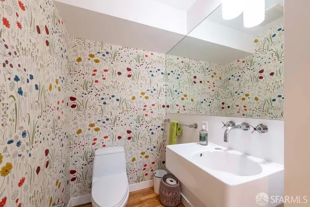 a bathroom with a sink and mirror with toilet