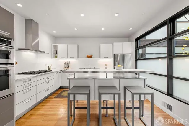 a kitchen with cabinets appliances and a dining table