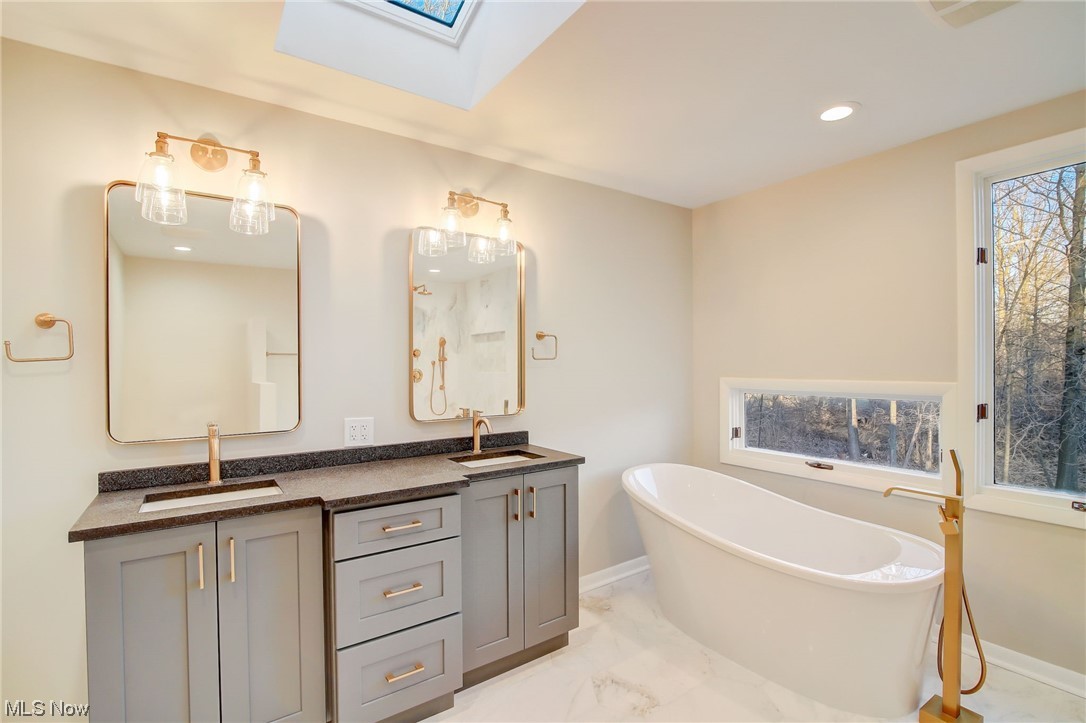 471 Snavely Road Cleveland, OH 44143 - Photo 17 of 35 Bathroom with tile flooring, a skylight, a tub, and double vanity