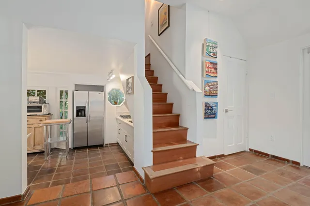 a kitchen with white cabinets and refrigerator
