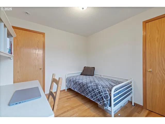 a bedroom with a bed and wooden floor