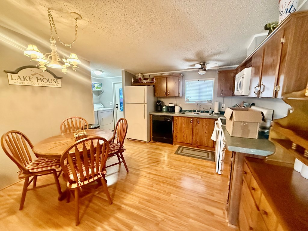 220 Sullivan Drive Springville, TN 38256 - Photo 5 of 17 a kitchen with stainless steel appliances granite countertop a stove top oven a sink dishwasher and a dining table with wooden floor