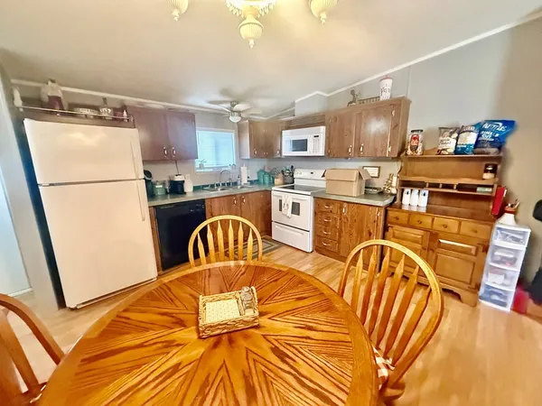 a kitchen with stainless steel appliances granite countertop a refrigerator a stove a sink dishwasher with a dining table and chairs