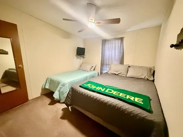 a bedroom with a bed mirror and a window