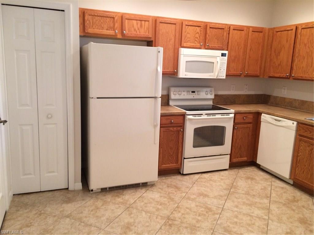 3954 Cherrybrook Loop Fort Myers, FL 33966 - Photo 4 of 16 a white refrigerator freezer and a stove sitting inside of a kitchen