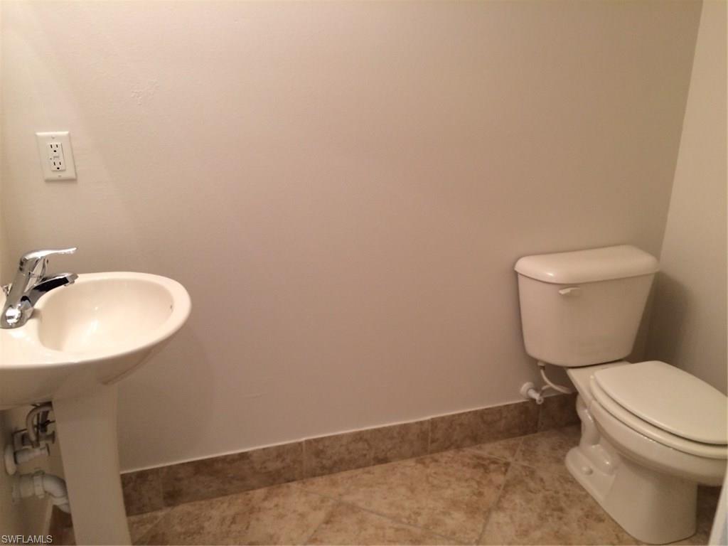3954 Cherrybrook Loop Fort Myers, FL 33966 - Photo 7 of 16 a white toilet sitting next to a bathroom sink