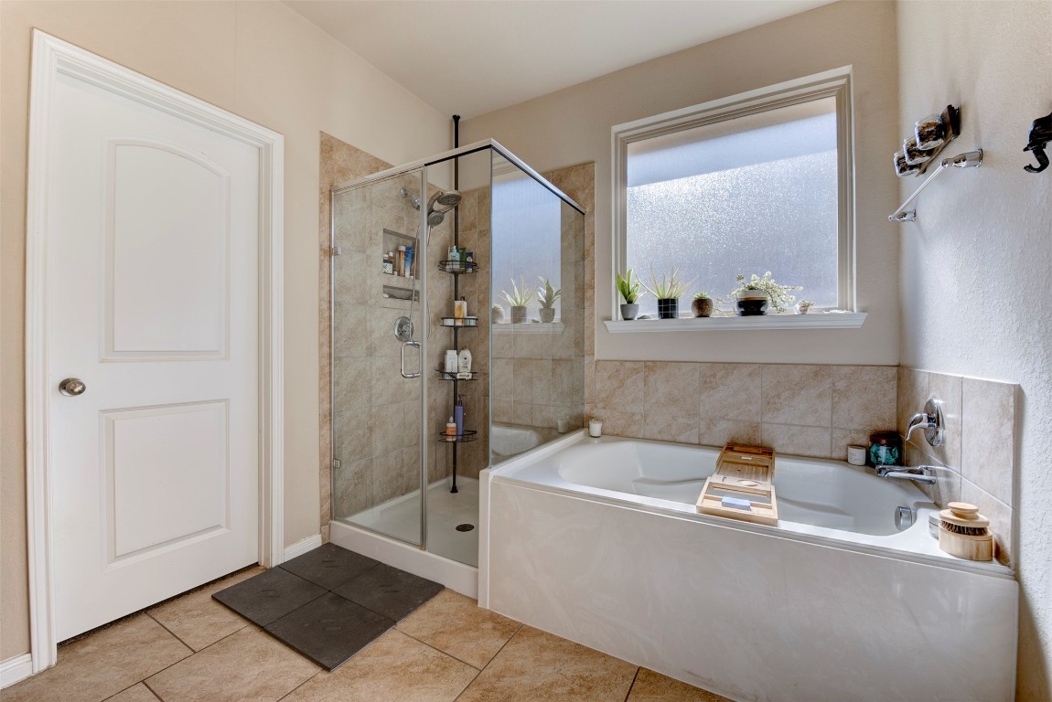 22939 Banff Brook Way Tomball, TX 77375 - Photo 15 of 25 Spa-like primary bathroom with a separate glass-enclosed shower, soaking tub, and ample natural light for a relaxing retreat.
