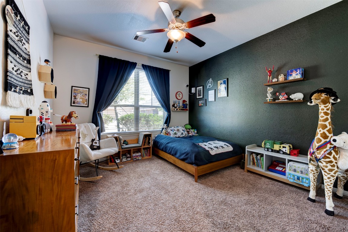 22939 Banff Brook Way Tomball, TX 77375 - Photo 17 of 25 Spacious secondary bedroom featuring plush carpet, natural light, and a stylish accent wall—perfect for guests or family.