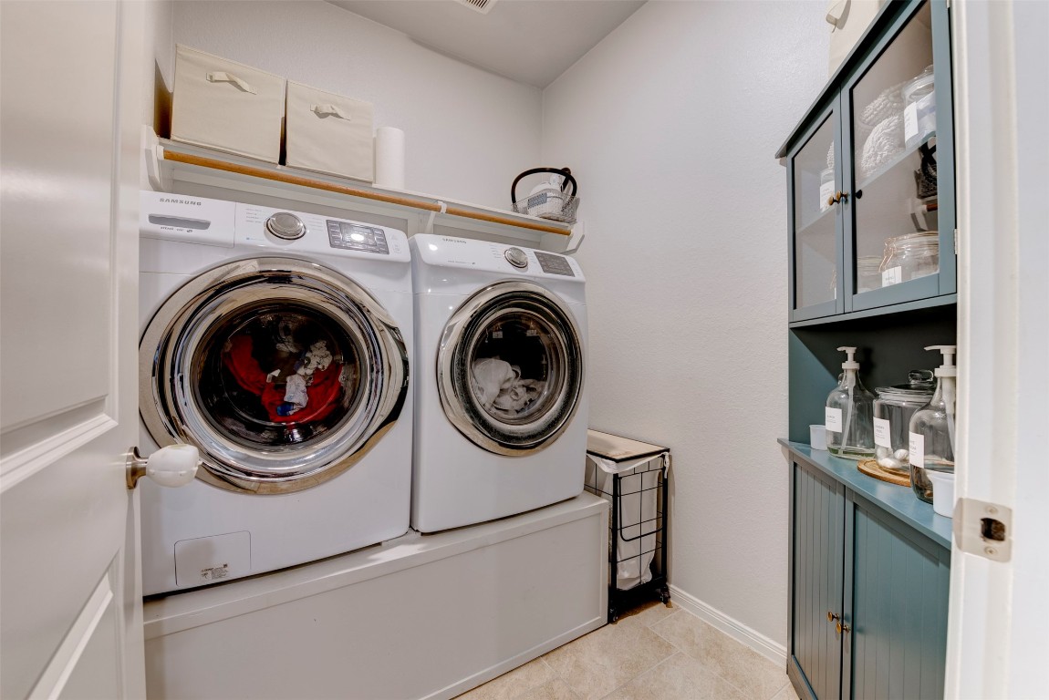 22939 Banff Brook Way Tomball, TX 77375 - Photo 20 of 25 Well-appointed laundry room with full-size washer and dryer, built-in shelving, and additional storage space for everyday convenience.