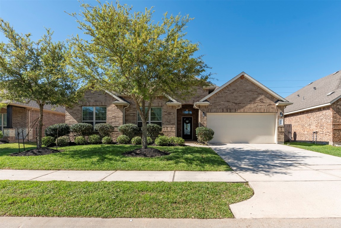 22939 Banff Brook Way Tomball, TX 77375 - Photo 2 of 25 Charming single-story brick home with great curb appeal, mature landscaping, and a welcoming front entry.